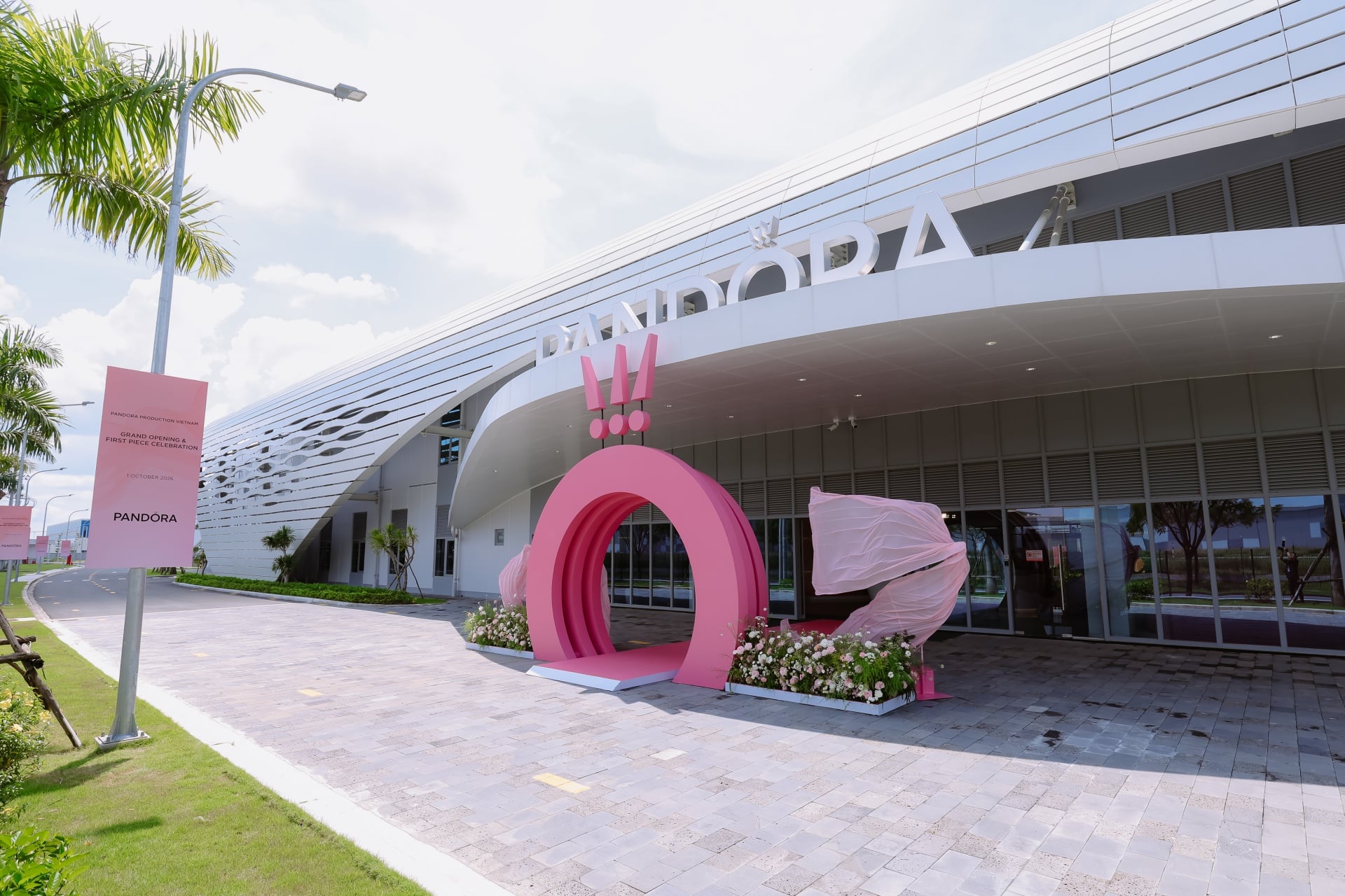 Die neue Pandora-Fabrik in Ho-Chi-Minh-Stadt: ein weisses Gebäude mit dem Pandora-Schriftzug und einem pinkfarbenen Torbogen am Eingang